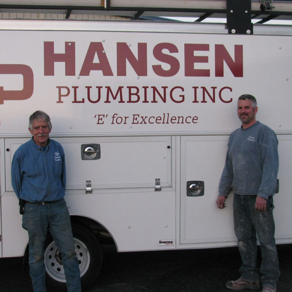 employees standing in front of hansen plumbing work truck